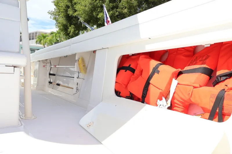 Slide: The Image of Storage compartment on 2006 Jupiter 38 HFS boat with life jackets and cleaning tools. - 33
