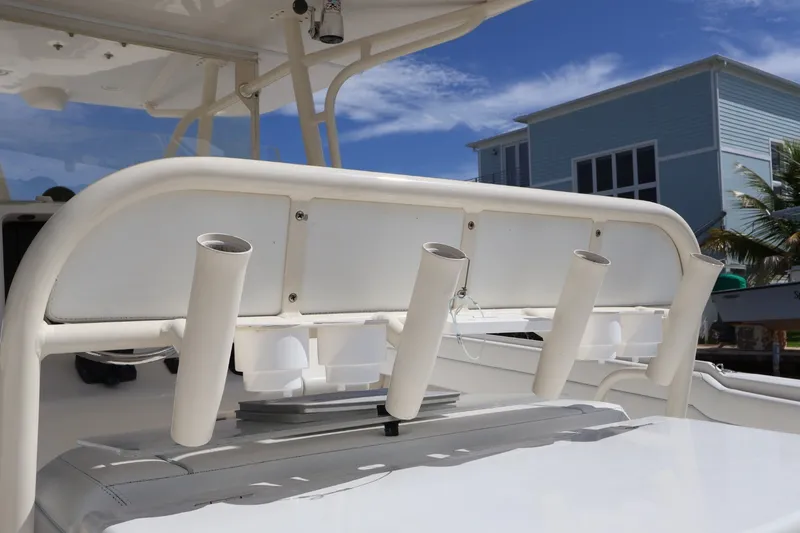 Slide: The Image of 2006 Jupiter 38 HFS boat with rod holders, docked near a coastal house. - 27