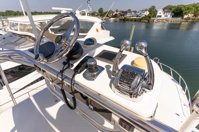 Slide: The Image of Helm of 2009 Cabo 40 Express yacht with steering wheel and controls, docked by waterfront homes. - 25