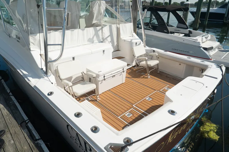 Slide: The Image of 2009 Cabo 40 Express boat with teak deck and seating at marina. - 9