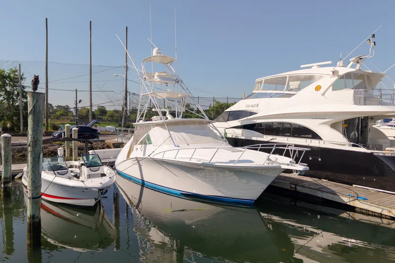 Slide: The Image of 2009 Cabo 40 Express yacht docked alongside other boats in a marina. - 4