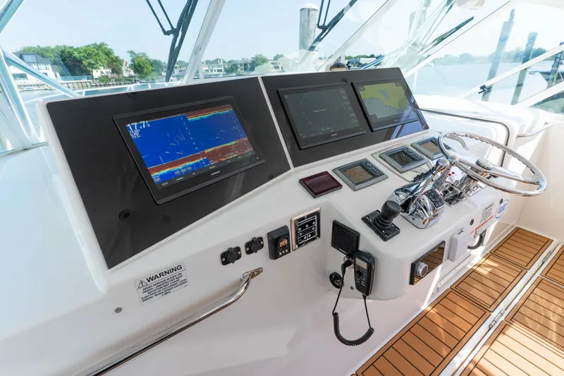 Slide: The Image of 2009 Cabo 40 Express yacht helm with navigation screens and controls. - 1