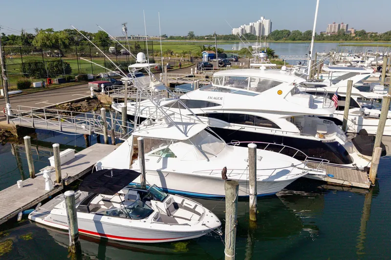 Slide: The Image of 2009 Cabo 40 Express yacht docked at a marina, surrounded by other boats. - 59