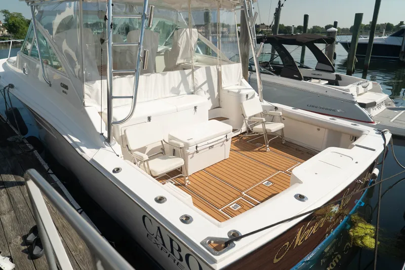 Slide: The Image of 2009 Cabo 40 Express yacht docked, featuring spacious deck and seating area. - 10