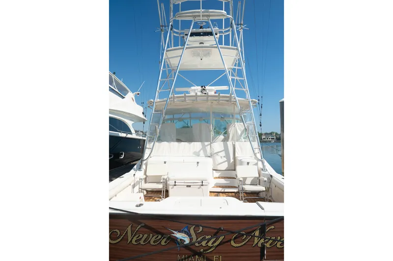 Slide: The Image of 2009 Cabo 40 Express yacht with tower, docked under clear blue sky. - 6