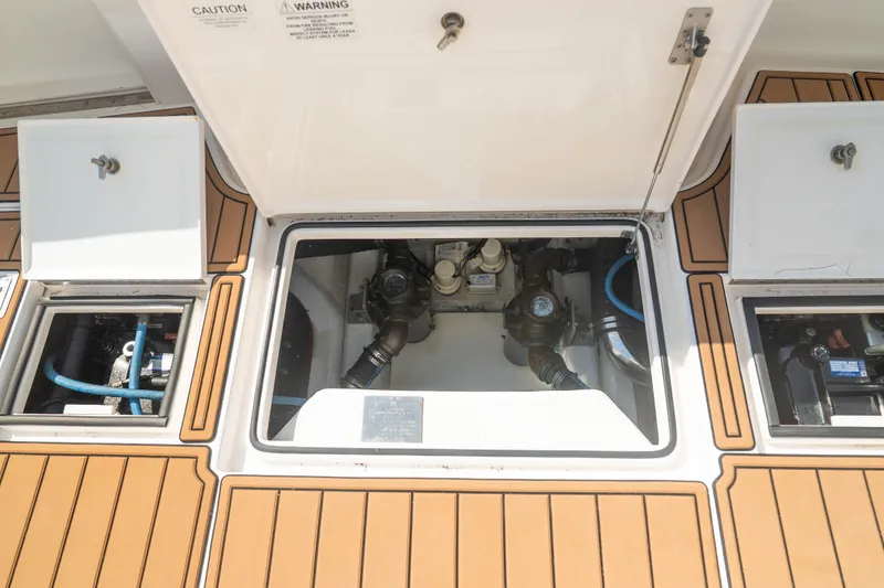 Slide: The Image of Engine compartment of a 2009 Cabo 40 Express boat with open hatches and visible components. - 43