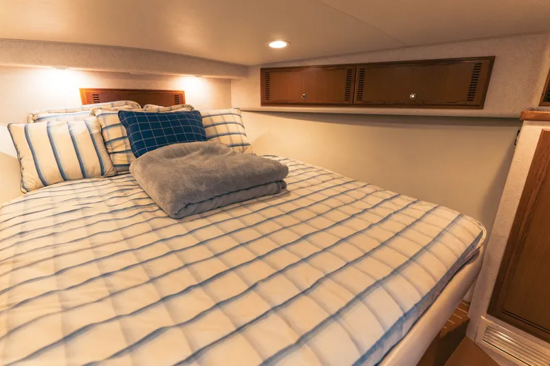 Slide: The Image of Cozy cabin bedroom in 2009 Cabo 40 Express yacht with striped bedding. - 33