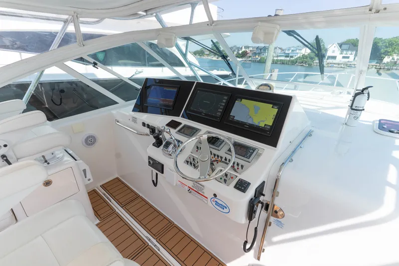Slide: The Image of Helm of 2009 Cabo 40 Express yacht with navigation screens and controls. - 18
