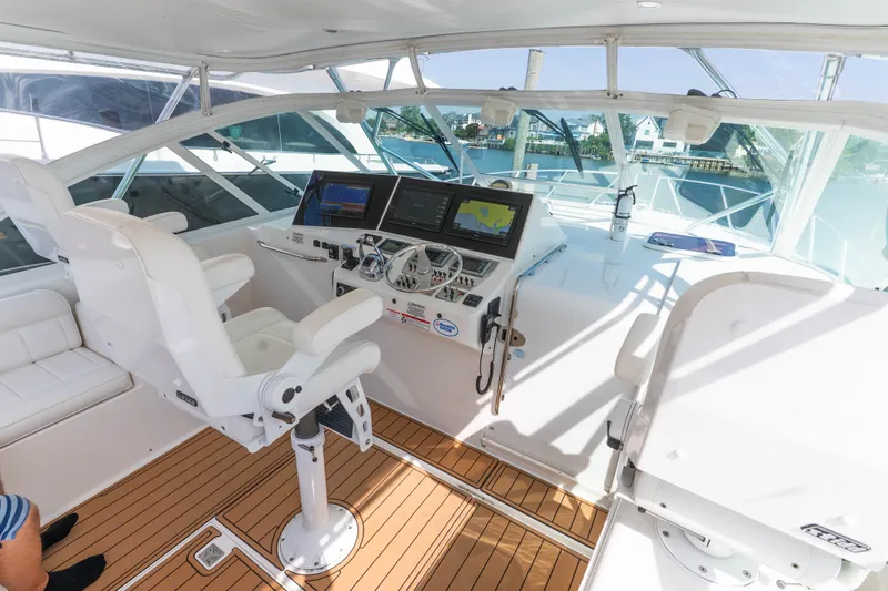 Slide: The Image of Helm of 2009 Cabo 40 Express yacht with modern navigation equipment and white seating. - 12