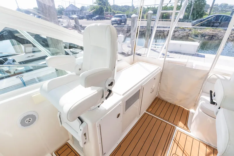Slide: The Image of 2009 Cabo 40 Express yacht interior with white captain's chair and teak flooring. - 15