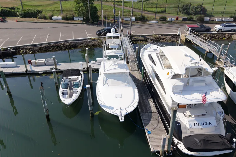 Slide: The Image of 2009 Cabo 40 Express yacht docked at marina, alongside other boats. - 58