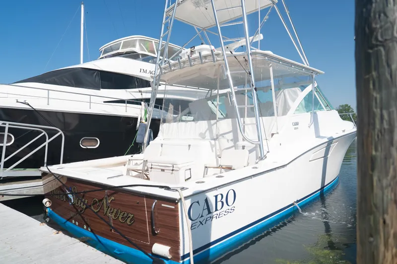 Slide: The Image of 2009 Cabo 40 Express boat docked beside a larger yacht. - 7
