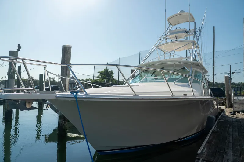 The Image of 2009 Cabo 40 Express yacht docked at marina under clear blue sky. - 5