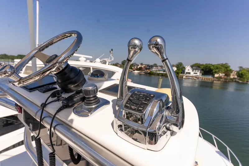Slide: The Image of Control panel of a 2009 Cabo 40 Express yacht with steering wheel and throttle levers. - 26
