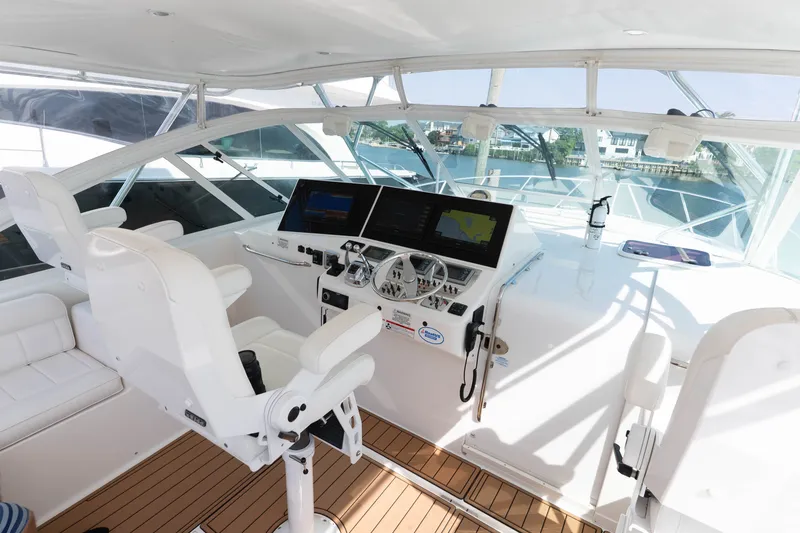 Slide: The Image of 2009 Cabo 40 Express yacht helm with modern navigation equipment and white seating. - 20