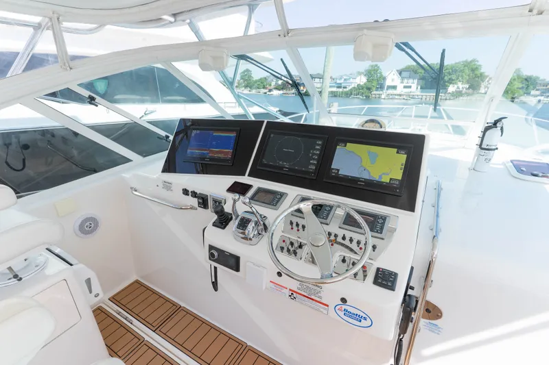 Slide: The Image of Helm of 2009 Cabo 40 Express yacht with navigation screens and steering wheel. - 19
