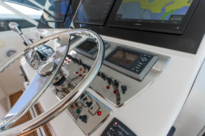 Slide: The Image of Control panel of a 2009 Cabo 40 Express yacht with navigation screens and steering wheel. - 22