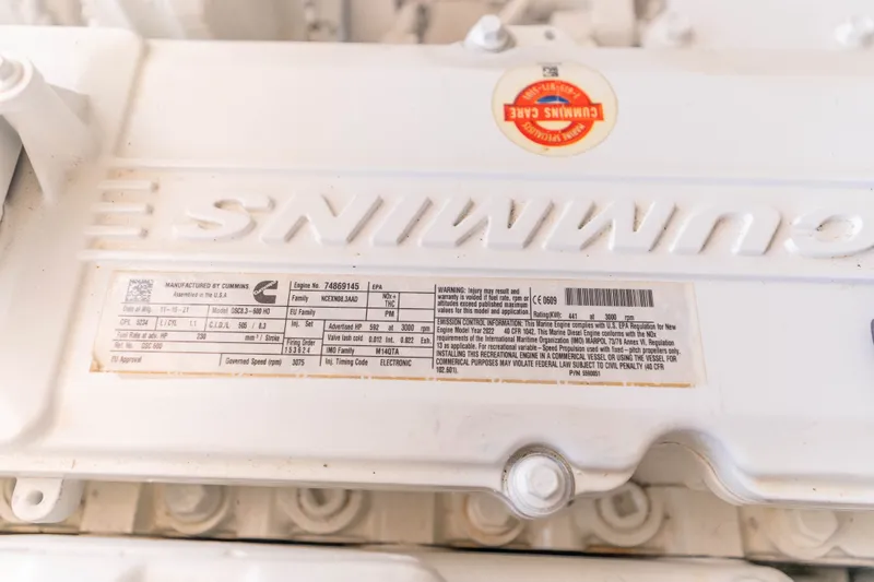 Slide: The Image of Cummins engine label on a 2009 Cabo 40 Express boat, showcasing specifications and warnings. - 56