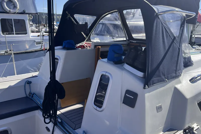 Slide: The Image of 1989 C&C 30 MKII sailboat cockpit with navy canopy and marina background. - 17
