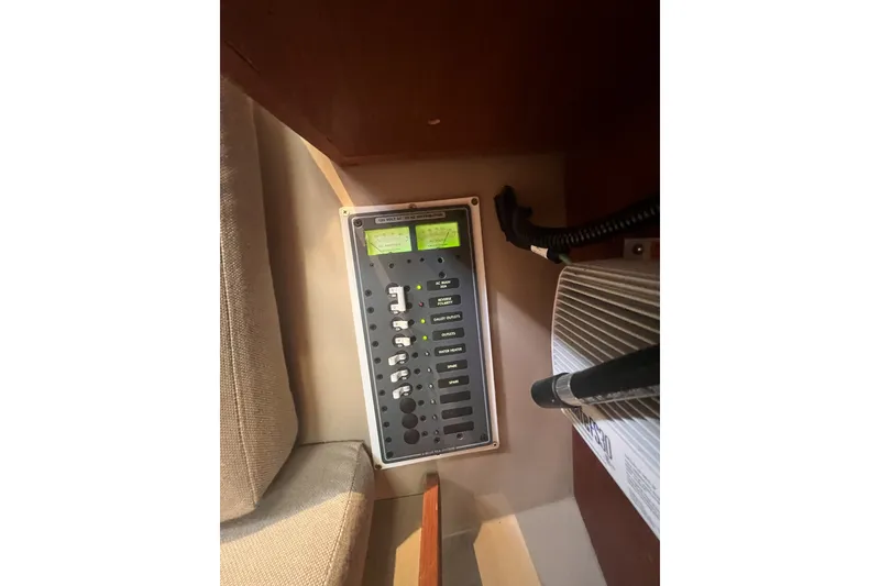 Slide: The Image of Electrical panel inside a 1989 C&C 30 MKII sailboat, featuring switches and meters. - 56