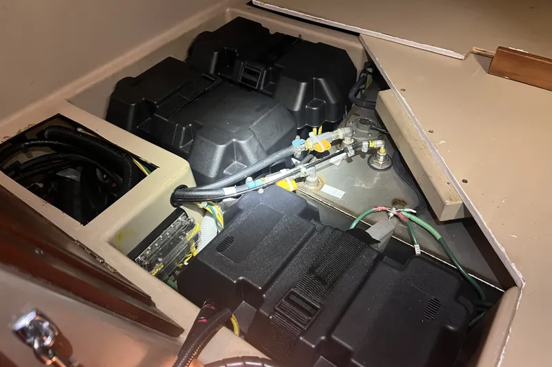 Slide: The Image of 1989 C&C 30 MKII yacht engine compartment with wiring and battery setup. - 85