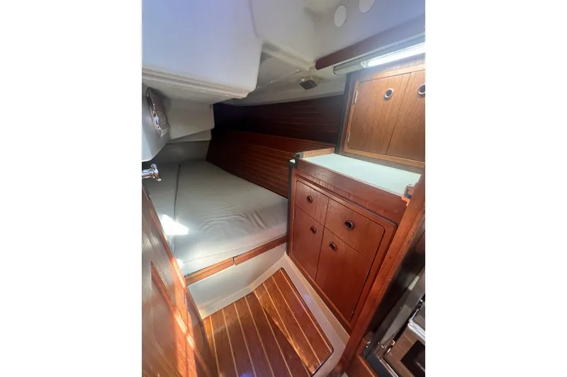 Slide: The Image of 1989 C&C 30 MKII yacht interior with wooden cabinetry and cozy sleeping area. - 49