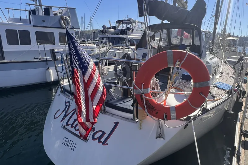 Slide: The Image of 1989 C&C 30 MKII sailboat docked in Seattle, displaying an American flag and life preserver. - 41