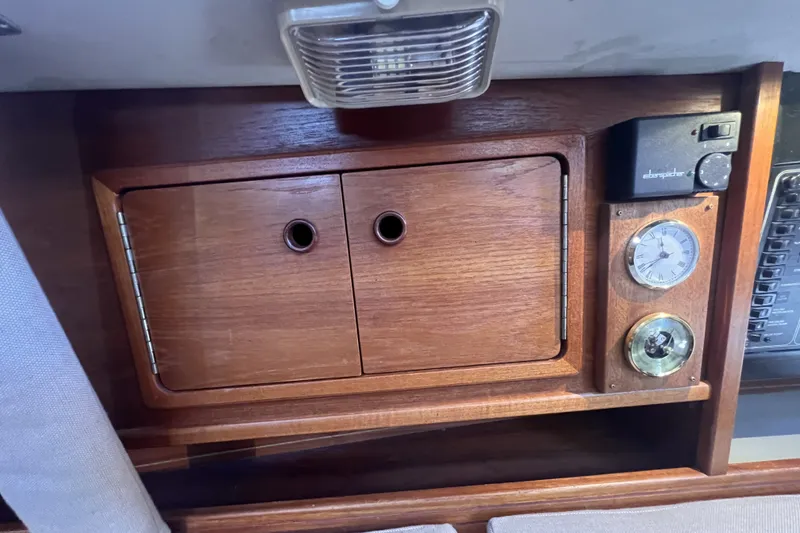 Slide: The Image of Wooden cabinet with clock and barometer on a 1989 C&C 30 MKII sailboat. - 59