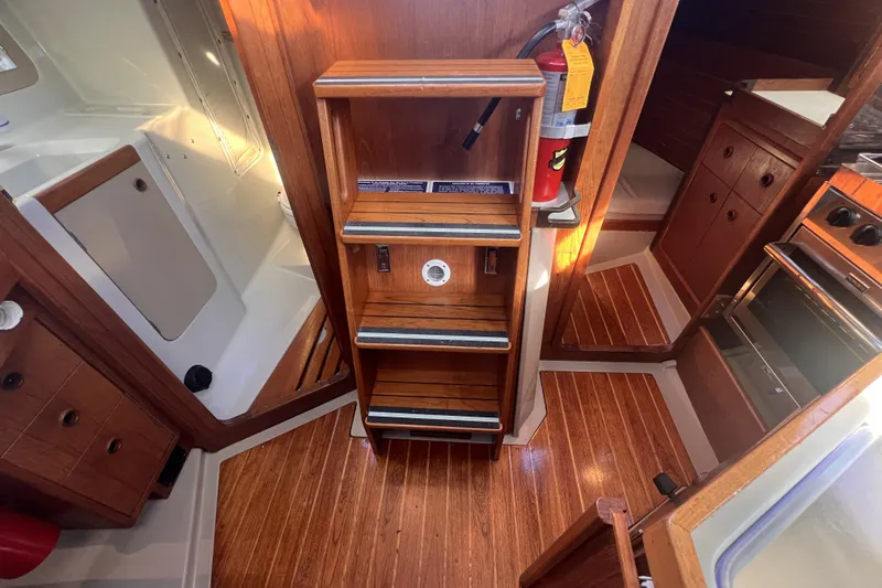 Slide: The Image of Interior of 1989 C&C 30 MKII sailboat with wooden steps and fire extinguisher. - 45