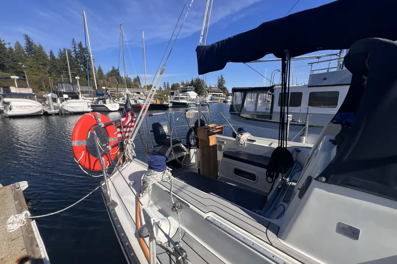 Slide: The Image of 1989 C&C 30 MKII sailboat docked in a marina, featuring a lifebuoy and American flag. - 14