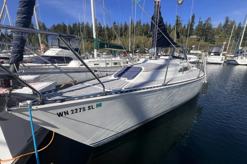 The Image of 1989 C&C 30 MKII sailboat docked in a marina, surrounded by other boats. - 0