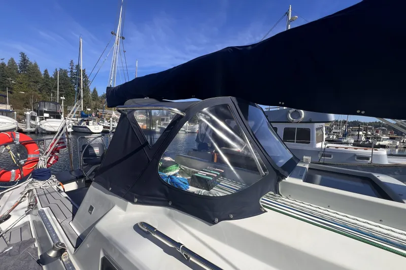 Slide: The Image of 1989 C&C 30 MKII sailboat docked at marina, featuring a covered cockpit and clear skies. - 15