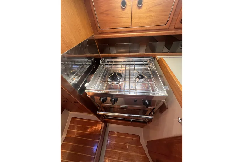 Slide: The Image of 1989 C&C 30 MKII yacht interior kitchen with stove and wooden cabinetry. - 66