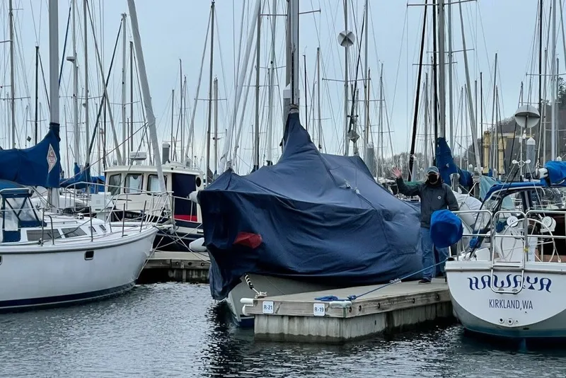 Slide: The Image of 1989 C&C 30 MKII sailboat covered at marina dock, surrounded by other boats. - 93