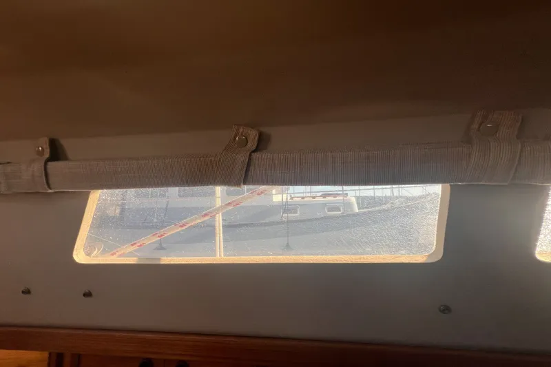 Slide: The Image of Interior view from a 1989 C&C 30 MKII sailboat, showing a window with a curtain. - 60