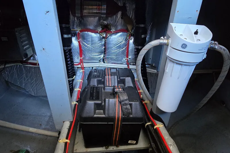 Slide: The Image of Engine room of a 1989 Silverton 34 Convertible boat, featuring wiring and a GE filter. - 35
