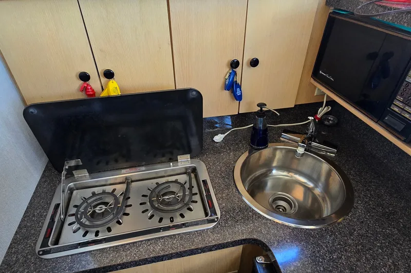 Slide: The Image of Compact kitchen area in a 1989 Silverton 34 Convertible boat with stove and sink. - 24