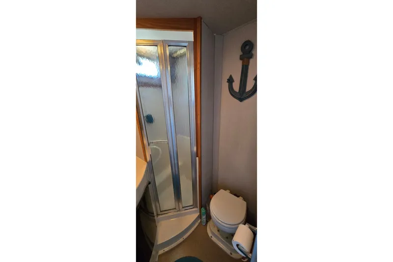 Slide: The Image of Bathroom interior of 1989 Silverton 34 Convertible boat with shower and anchor decor. - 30
