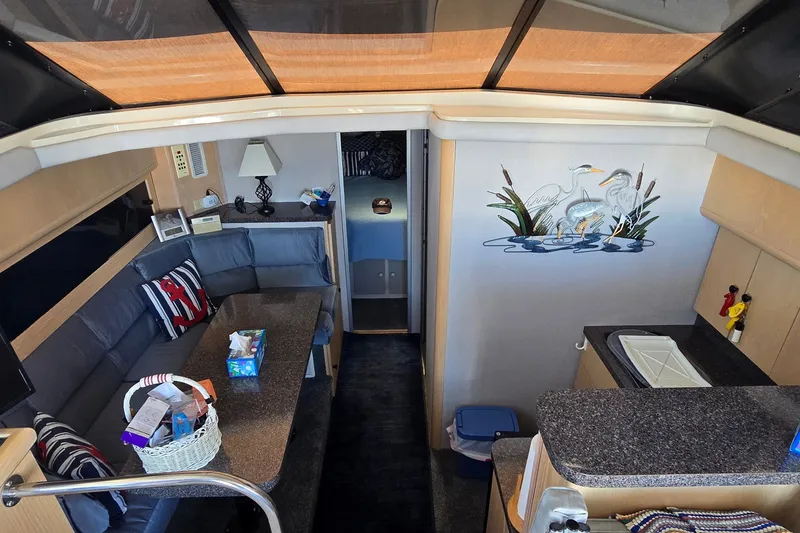 Slide: The Image of Interior of 1989 Silverton 34 Convertible yacht with cozy seating and decorative wall art. - 21