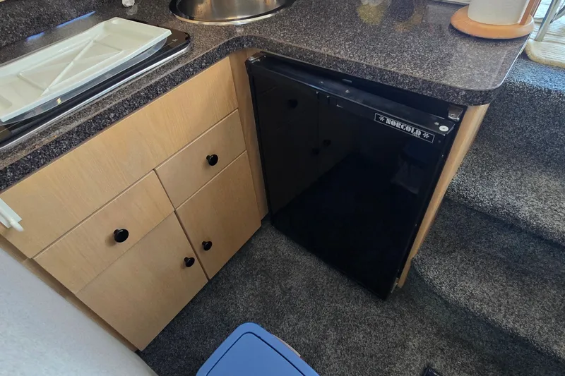 Slide: The Image of 1989 Silverton 34 Convertible interior with compact kitchen and Norcold refrigerator. - 25