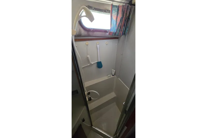 Slide: The Image of 1989 Silverton 34 Convertible boat shower with curtain and handheld showerhead. - 31
