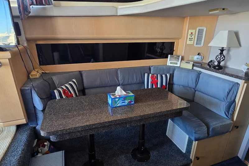 Slide: The Image of Interior of a 1989 Silverton 34 Convertible yacht with cozy seating and a granite table. - 22
