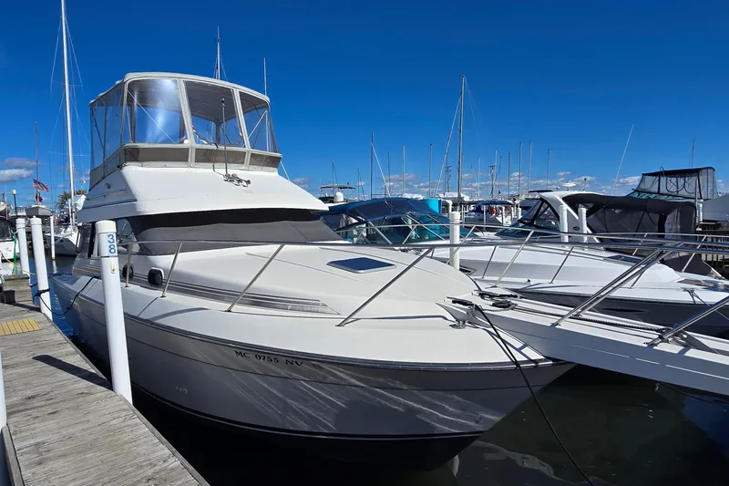 The Image of 1989 Silverton 34 Convertible yacht docked at marina under clear blue sky. - 0