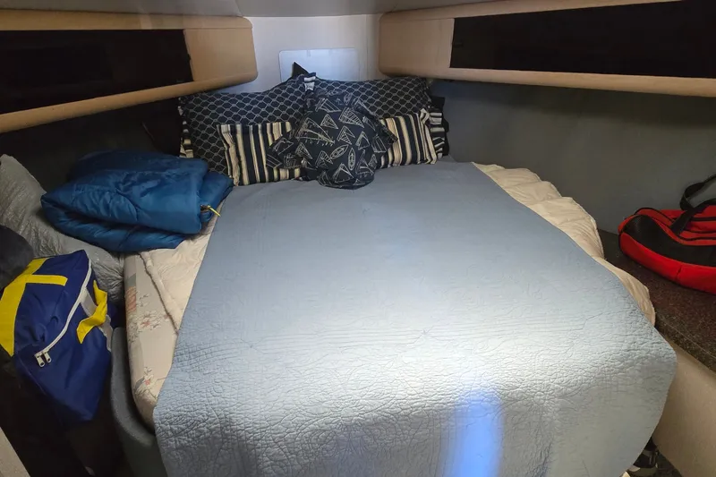 Slide: The Image of Cozy cabin interior of 1989 Silverton 34 Convertible with blue bedding and nautical pillows. - 26