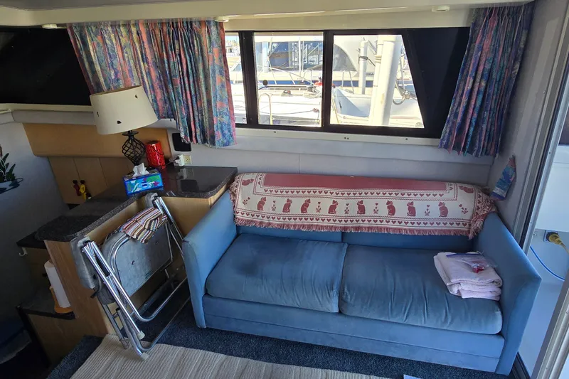 Slide: The Image of Interior of 1989 Silverton 34 Convertible with blue sofa and nautical decor. - 19