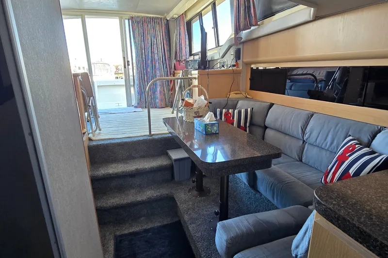Slide: The Image of Interior of a 1989 Silverton 34 Convertible yacht with cozy seating and dining area. - 28