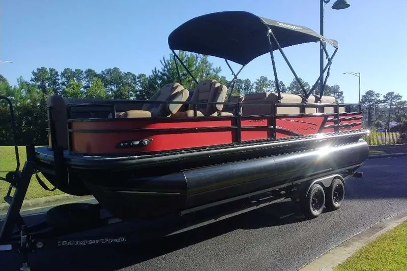 Slide: The Image of 2027 Ranger 223FC pontoon boat with canopy on trailer, parked outdoors. - 15
