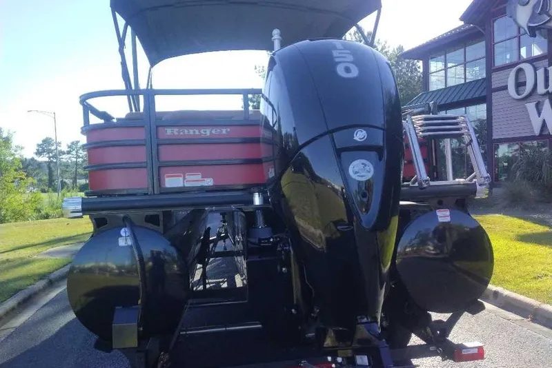 Slide: The Image of 2027 Ranger 223FC boat with powerful outboard motor, parked outdoors. - 12