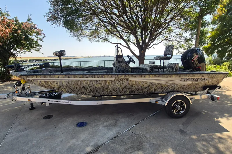 Slide: The Image of 2027 Ranger RB190 boat on trailer, camo design, parked near waterfront. - 1