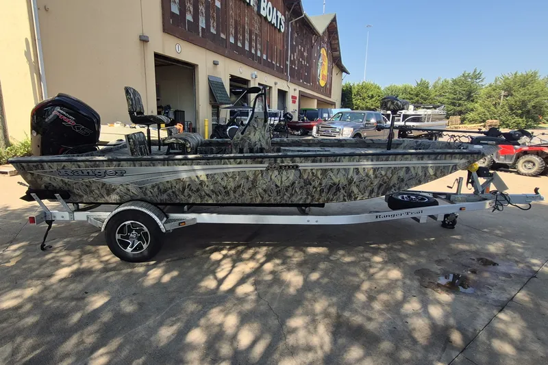 Slide: The Image of 2027 Ranger RB190 boat with camouflage design on a trailer outside a store. - 4